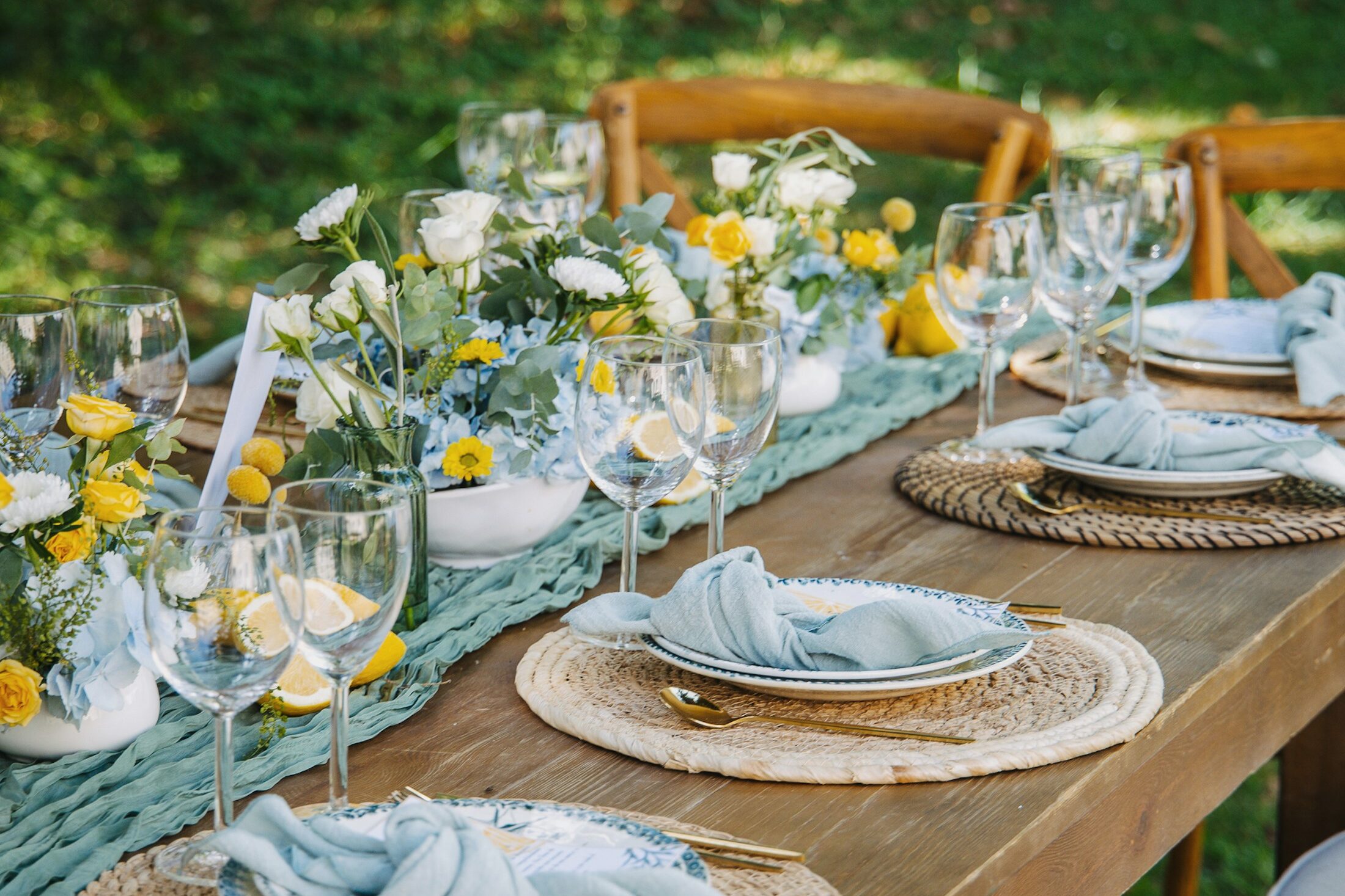 A dinner table set outdoors with flowers, glasses and linen napkins. Illustrative stock photograph, not an Almajour property