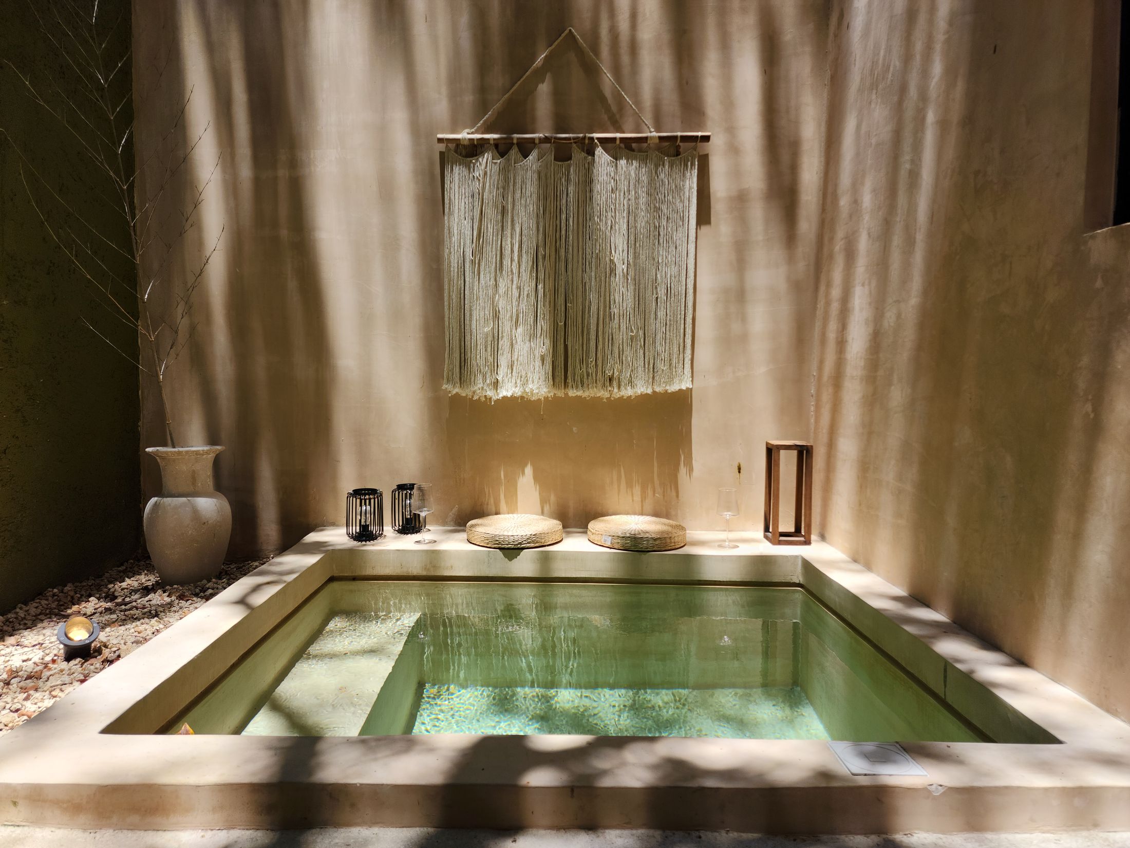 A stone bath filled with clear water in soft light. Illustrative stock photograph, not an Almajour property